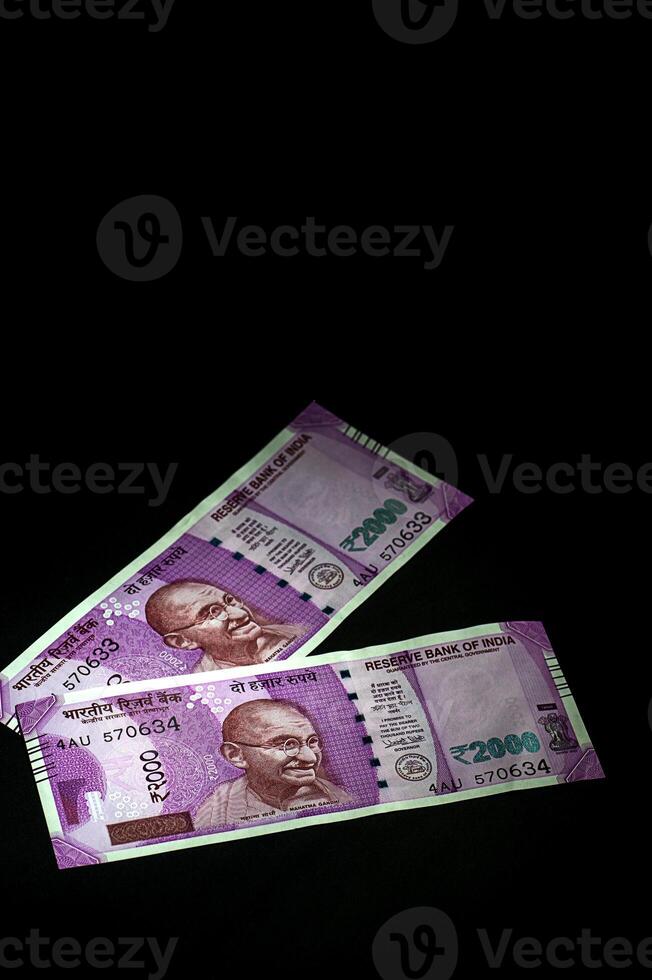 Two indian rupees are shown in the dark photo
