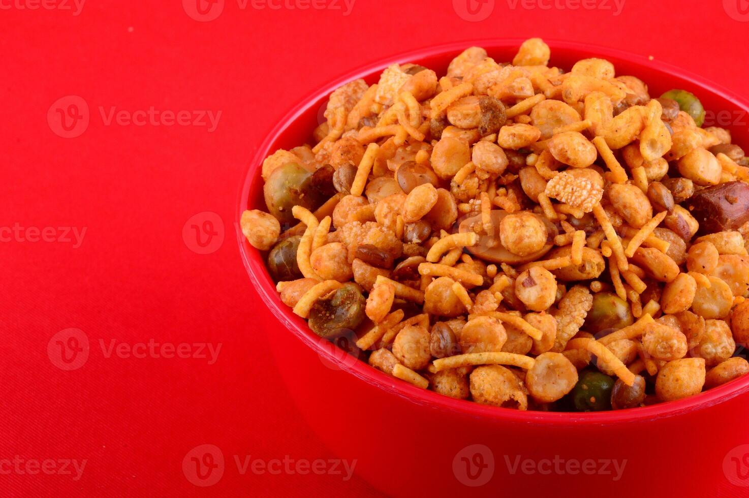 A bowl of mixed nuts and beans on a red surface photo