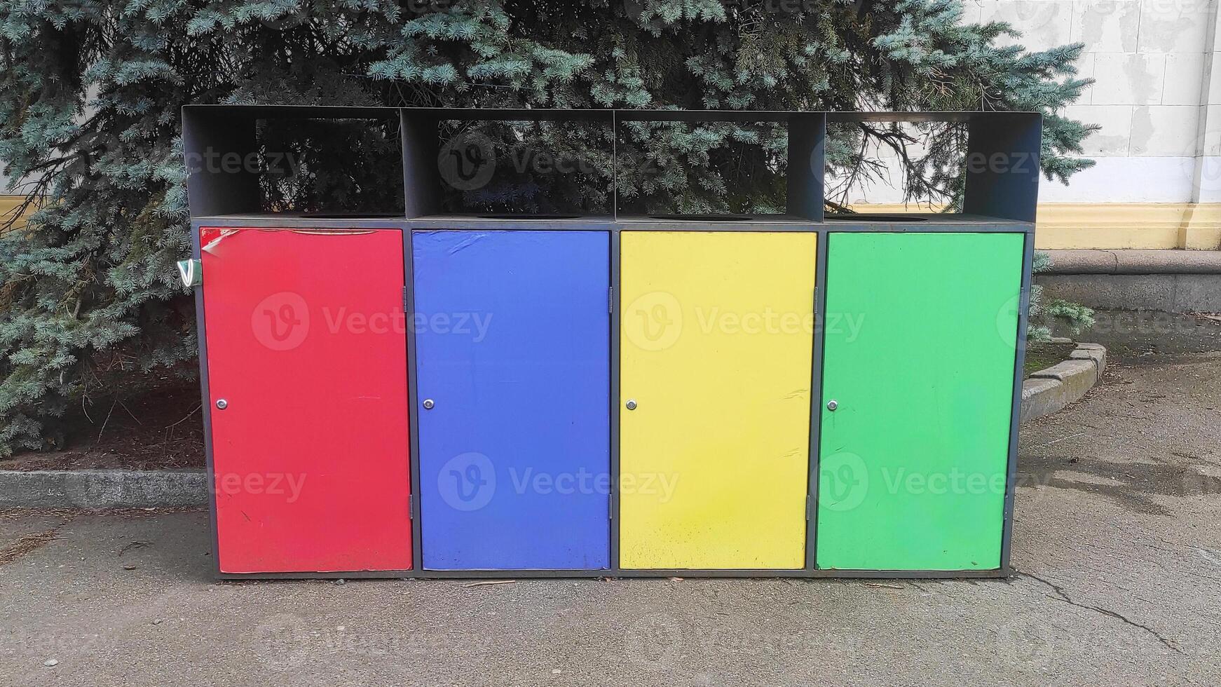 Colored trash bins red, blue, yellow, green for organic waste, paper, plastic, metal, glass in the city park of the city photo