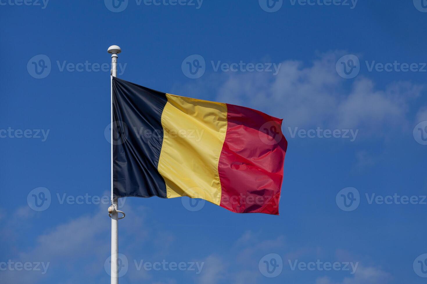 Belgium flag waving atop of its pole photo
