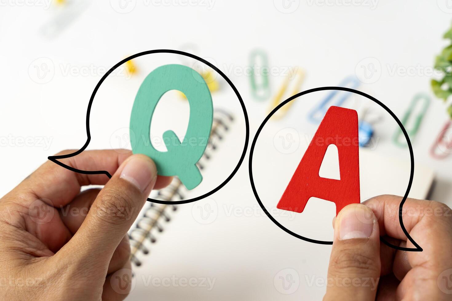 Q and A written on a notepad Work desk with electronic equipment computer and paper wooden table from above. photo