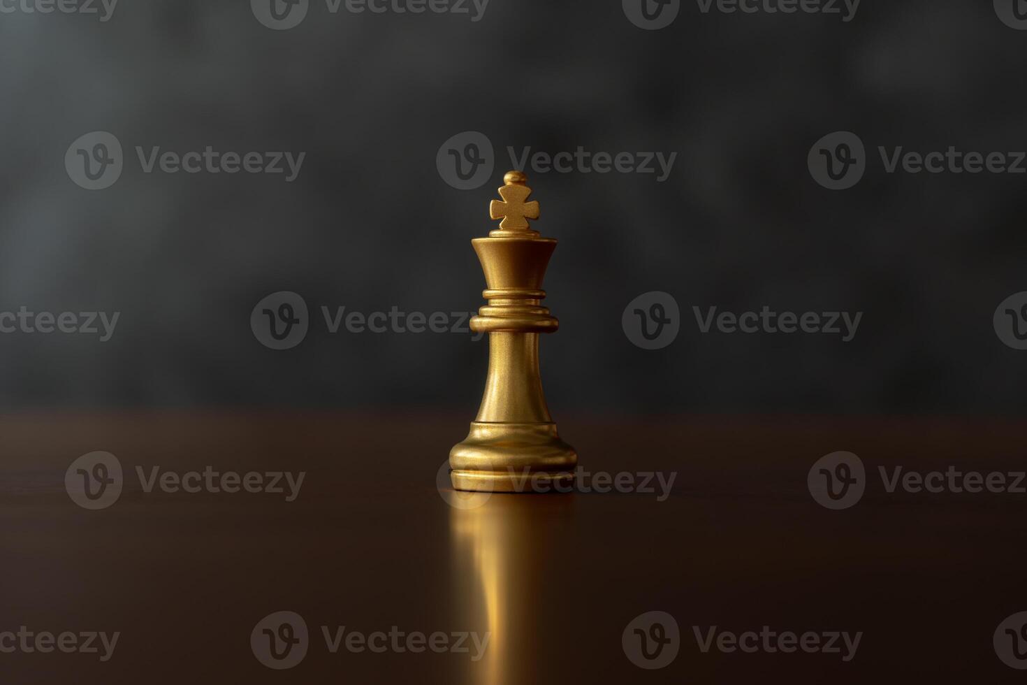 Close up the golden queen chess piece standing alone on a chessboard on dark background. photo