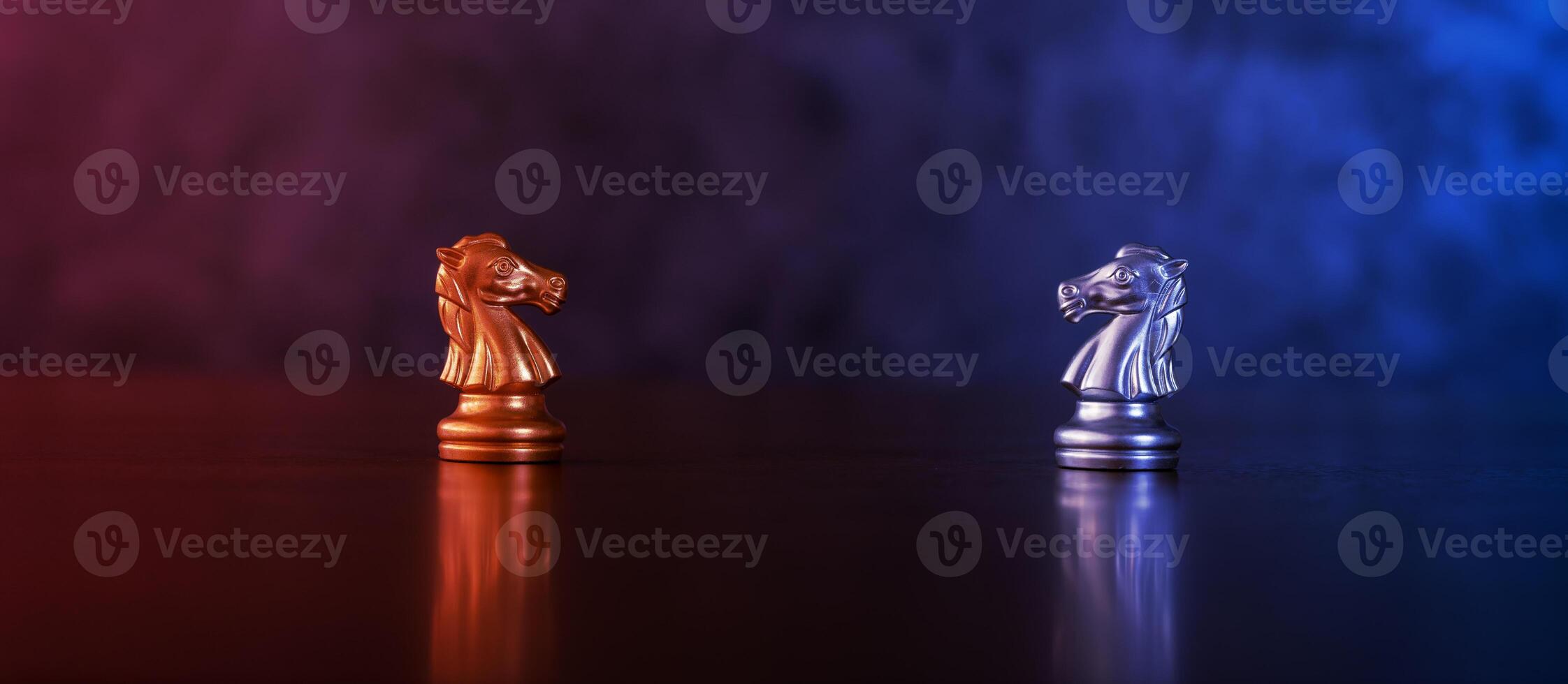 Chess pieces knights facing each other for a standoff. Chess knights confronting each other. Chess knights head to head. Chess horses face each other in warm and cold tones. photo