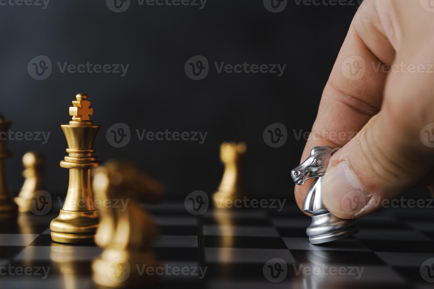 Knight black chess piece on chessboard. The hands of a businessman move a chess figure in a successful tournament played. photo