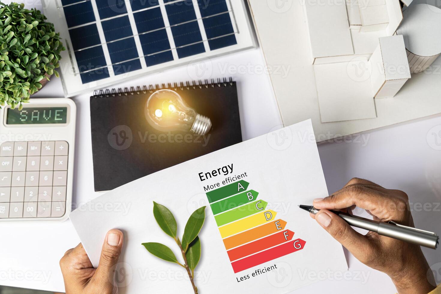 Energy efficiency concept with energy level chart Tabletop energy efficiency graph with house diagram calculator Solar panels. Businessman planning to use energy. photo