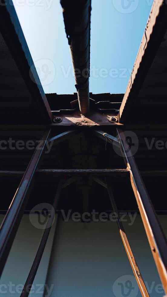 rusty metal structure with a pipe running along the top photo