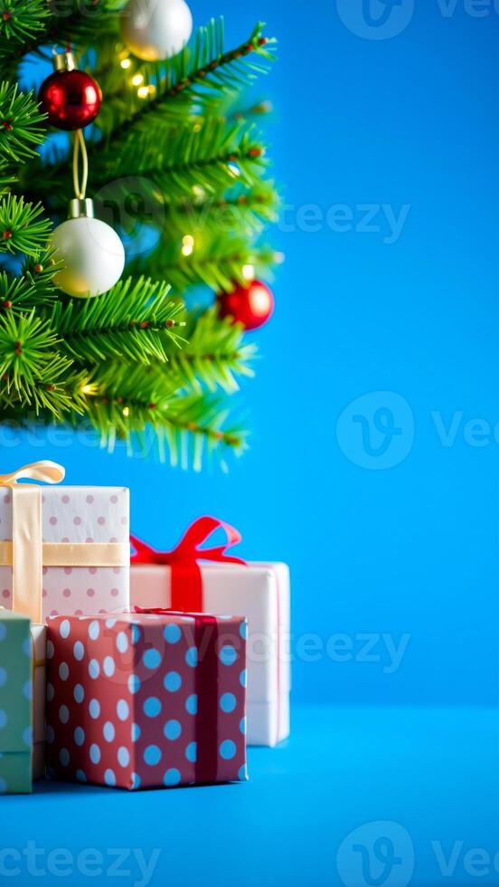 decorated evergreen tree with gifts on a blue background photo