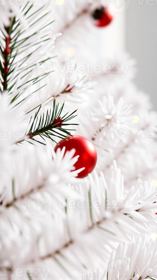 red ornament on a white artificial pine tree branch photo