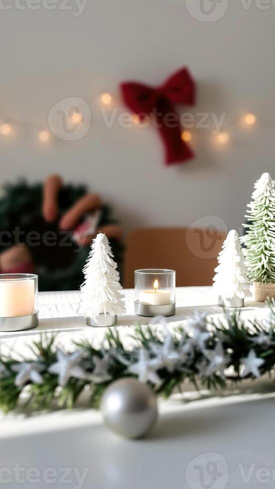 festive table setting with a lit candle small white trees photo