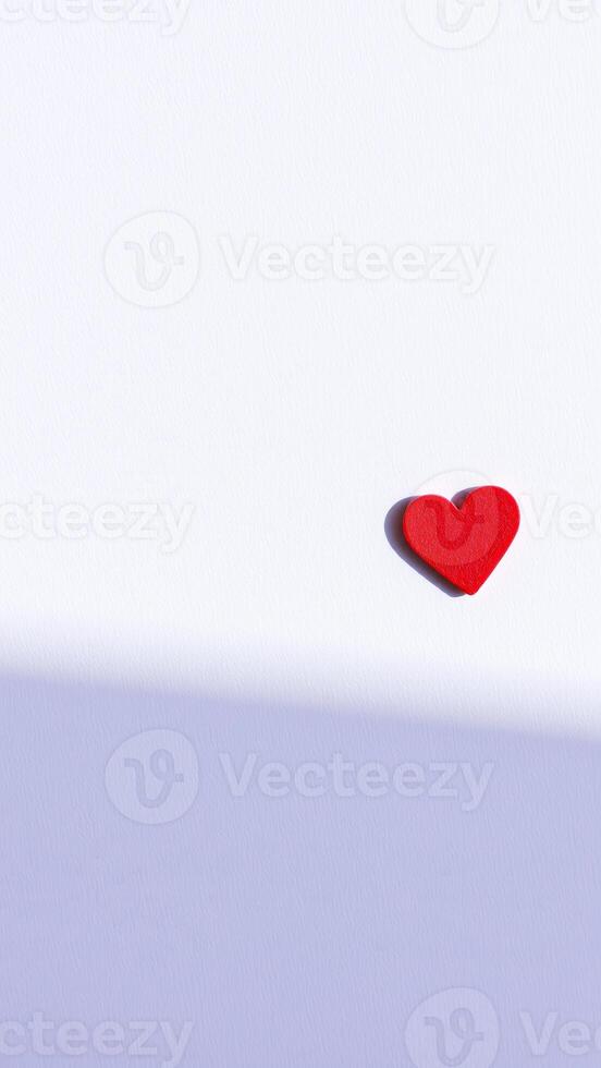 single red heart on a white textured background photo