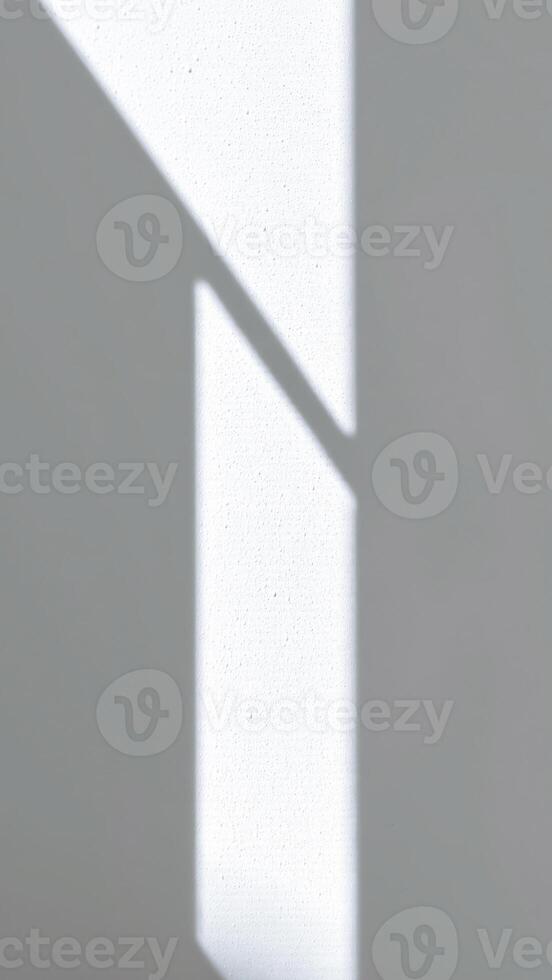 sunlight illuminates a white wall with geometric shadows photo