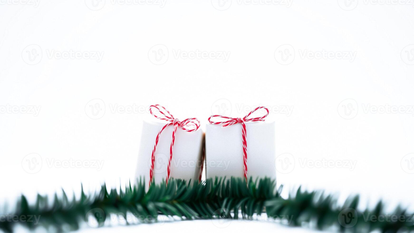 two white cylindrical objects tied with red white ribbon on a white surface with a green garland photo