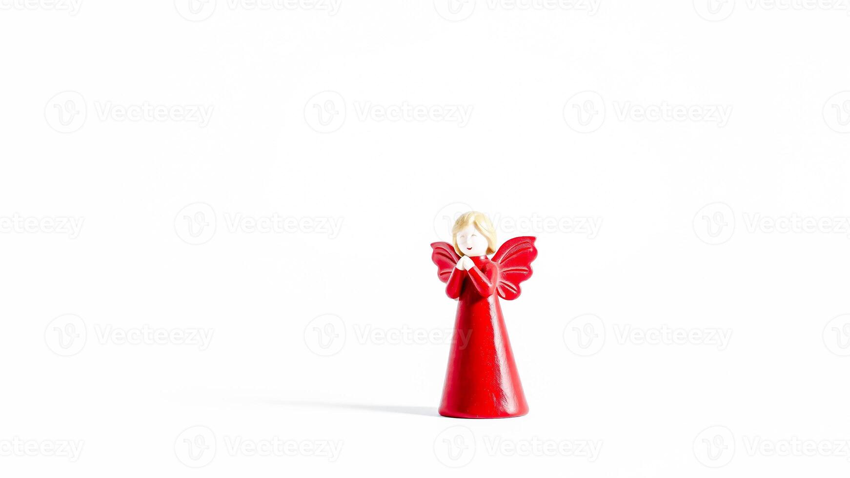 small red angel figurine stands prayer photo