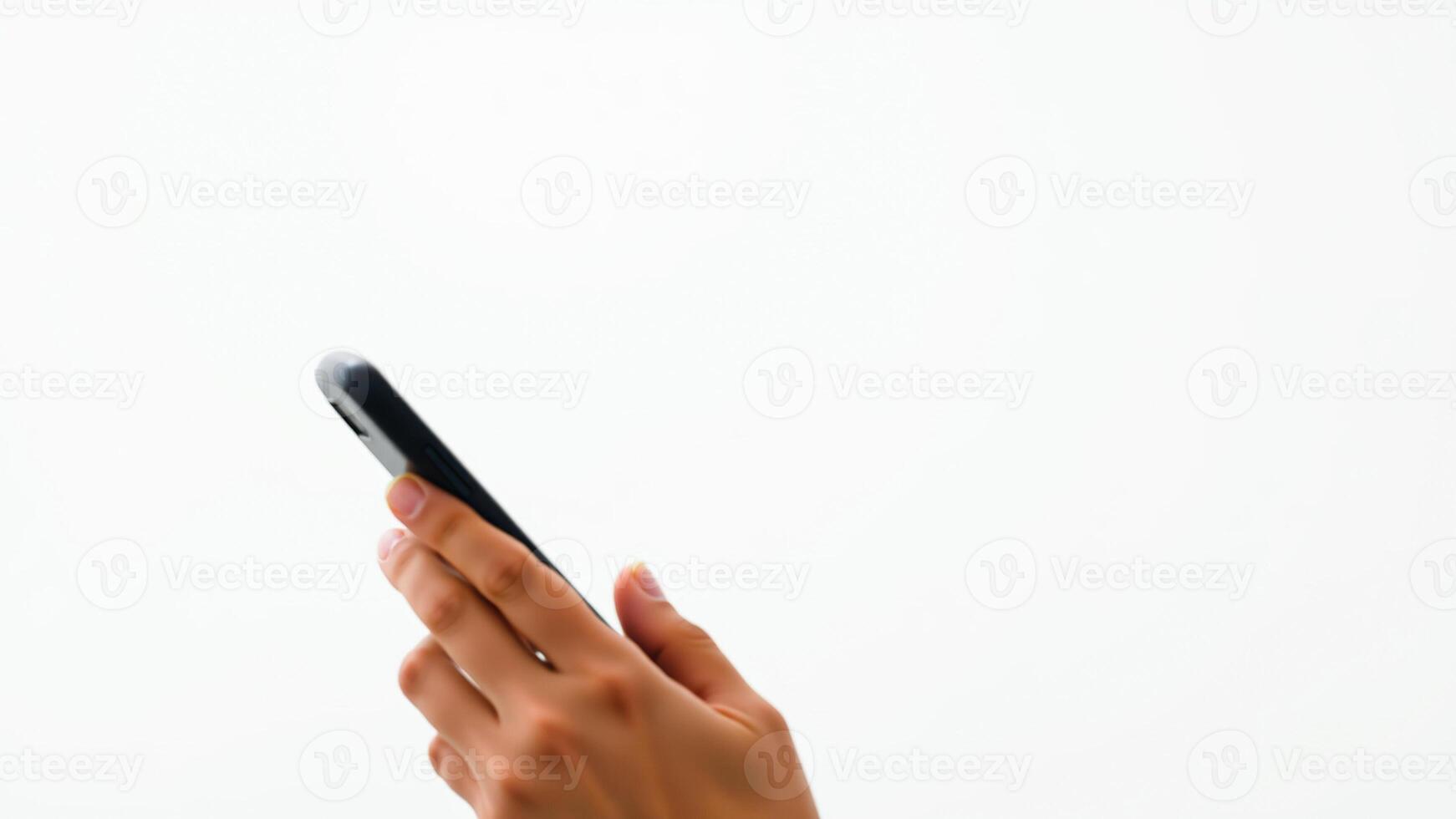 hand holding a black mobile phone against a white background photo