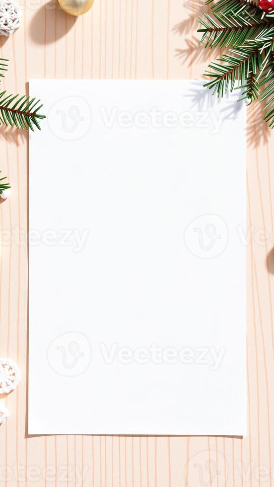 blank white paper with evergreen branches decorations on a woodgrain surface photo