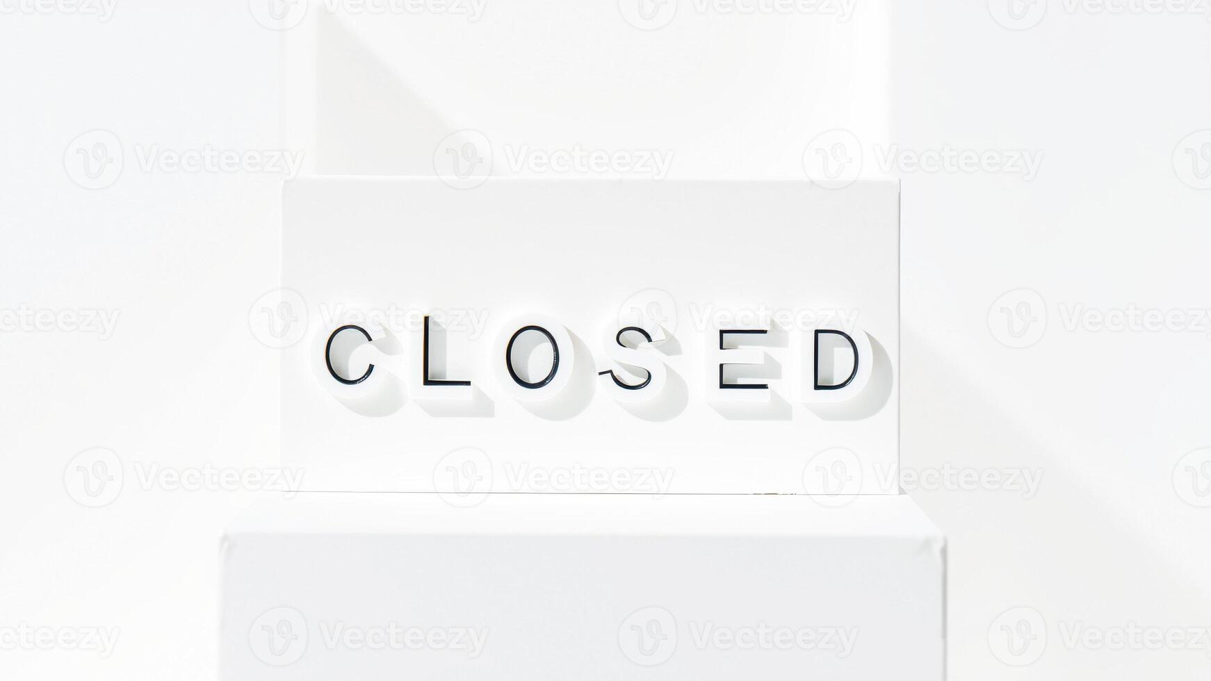 white sign with black lettering reads closed photo