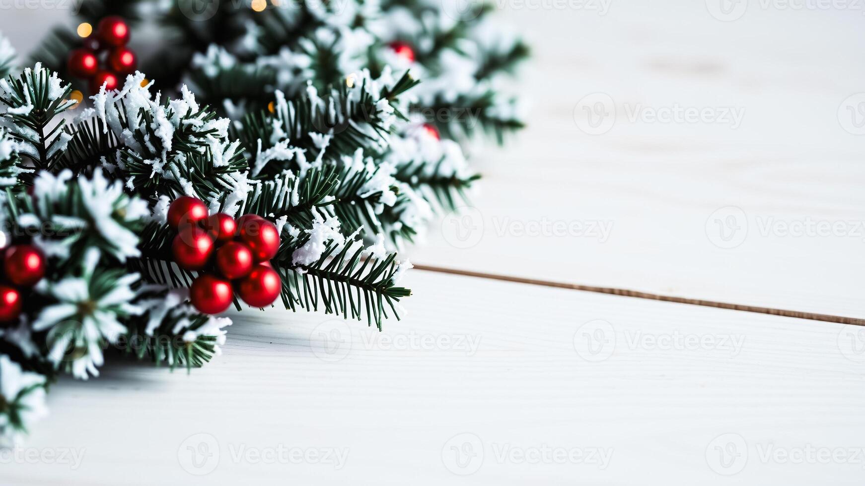 snowy evergreen branch with red berries on white wood photo