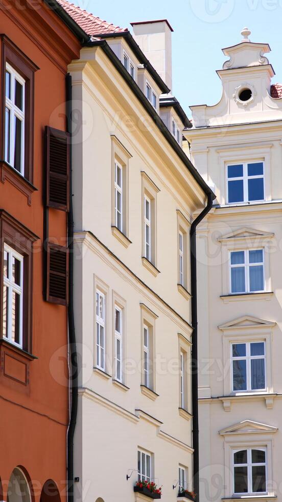 white building with multiple windows stands beside an building with a wooden shutter photo