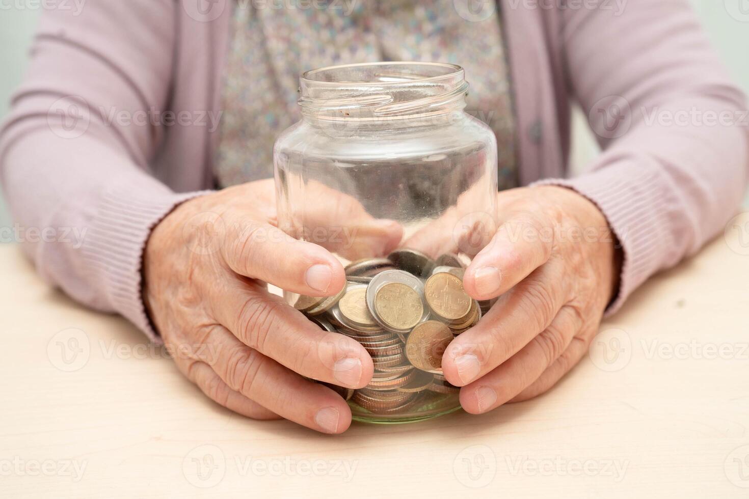 Retired Asian elderly woman counting coins money and worry about monthly expenses and treatment fee payment. photo