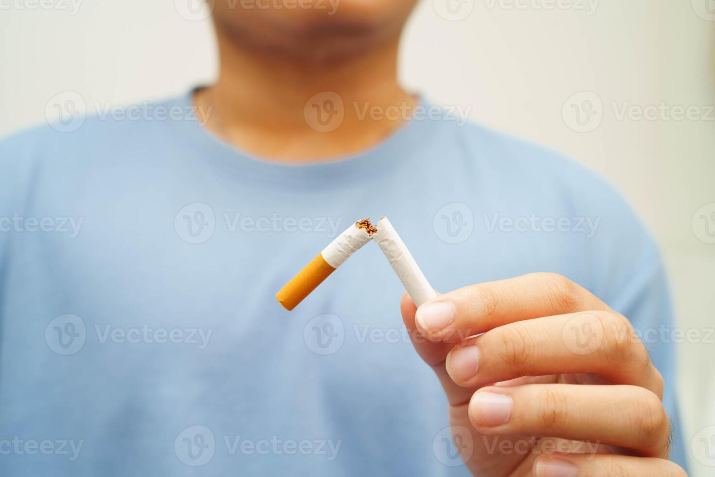 Quit smoking, Asian man breaking destroy cigarette in hand. photo