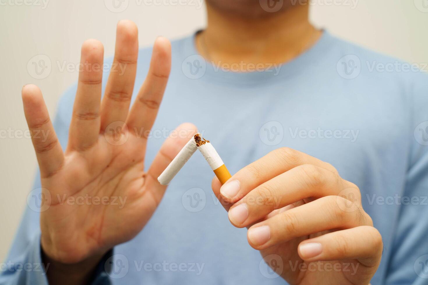 Quit smoking, Asian man breaking destroy cigarette in hand. photo