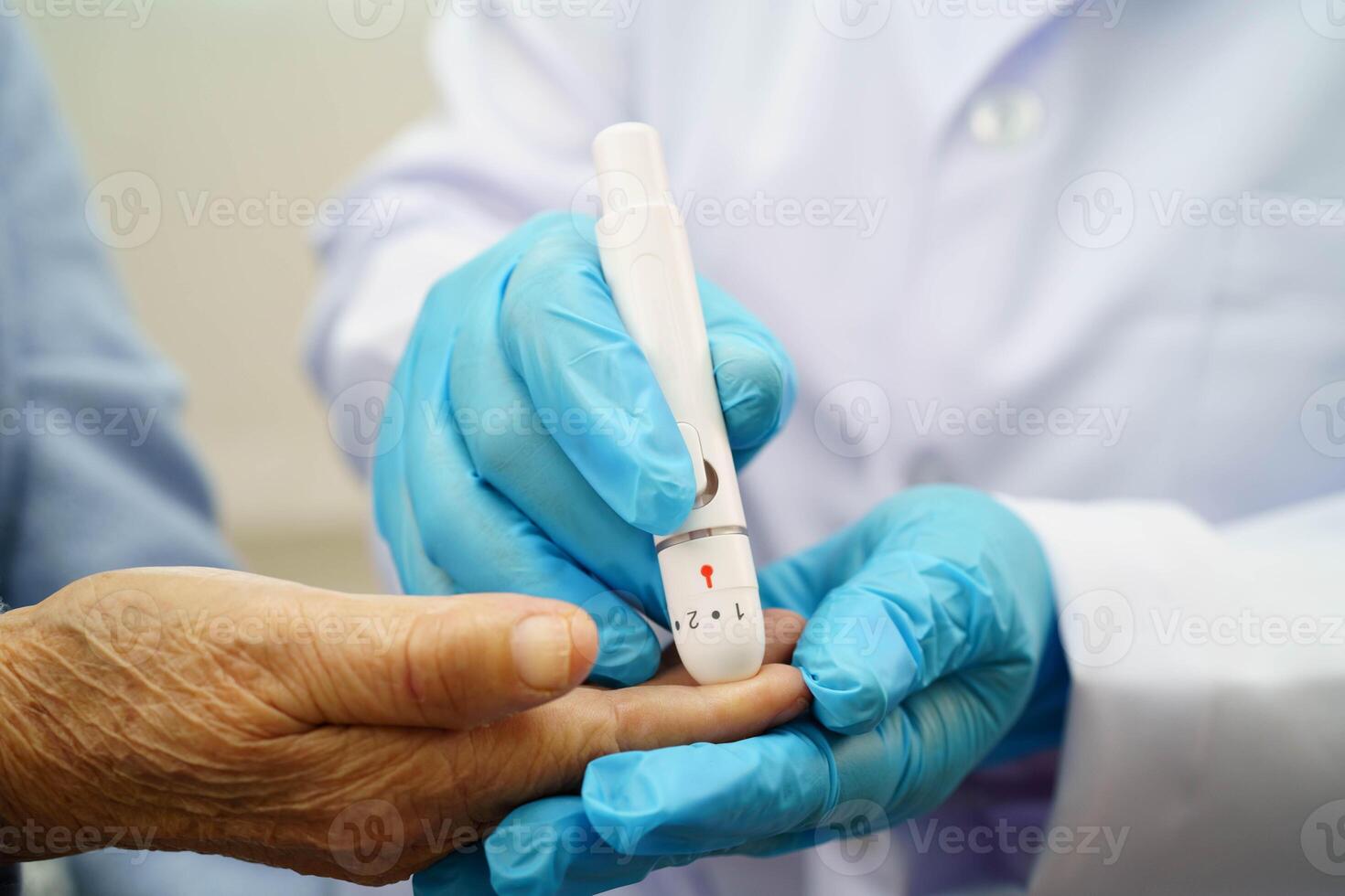Asian doctor using digital glucose meter for check sample blood sugar level to treatment diabetes. photo