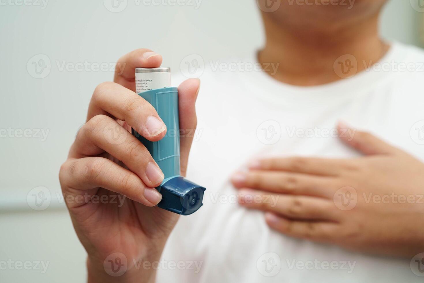 Asthma and chronic obstructive pulmonary disease COPD, Asian young man using metered dose inhaler MDI. photo
