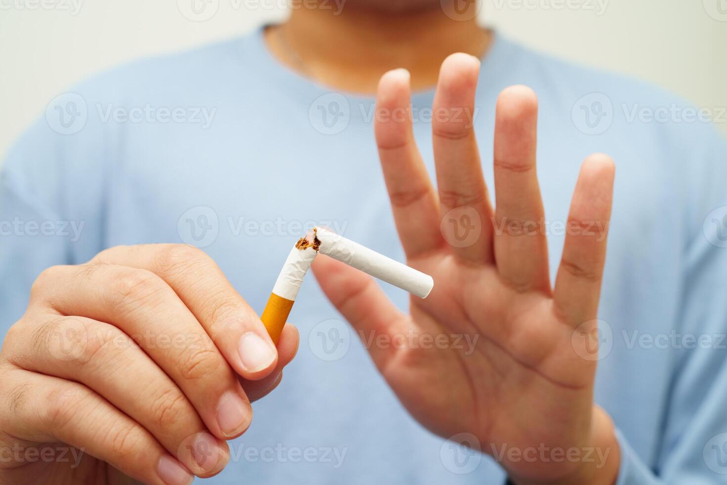 Quit smoking, Asian man breaking destroy cigarette in hand. photo