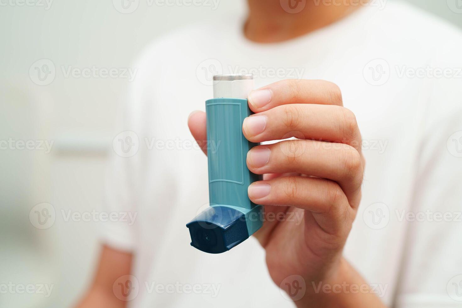 Asthma and chronic obstructive pulmonary disease COPD, Asian young man using metered dose inhaler MDI. photo
