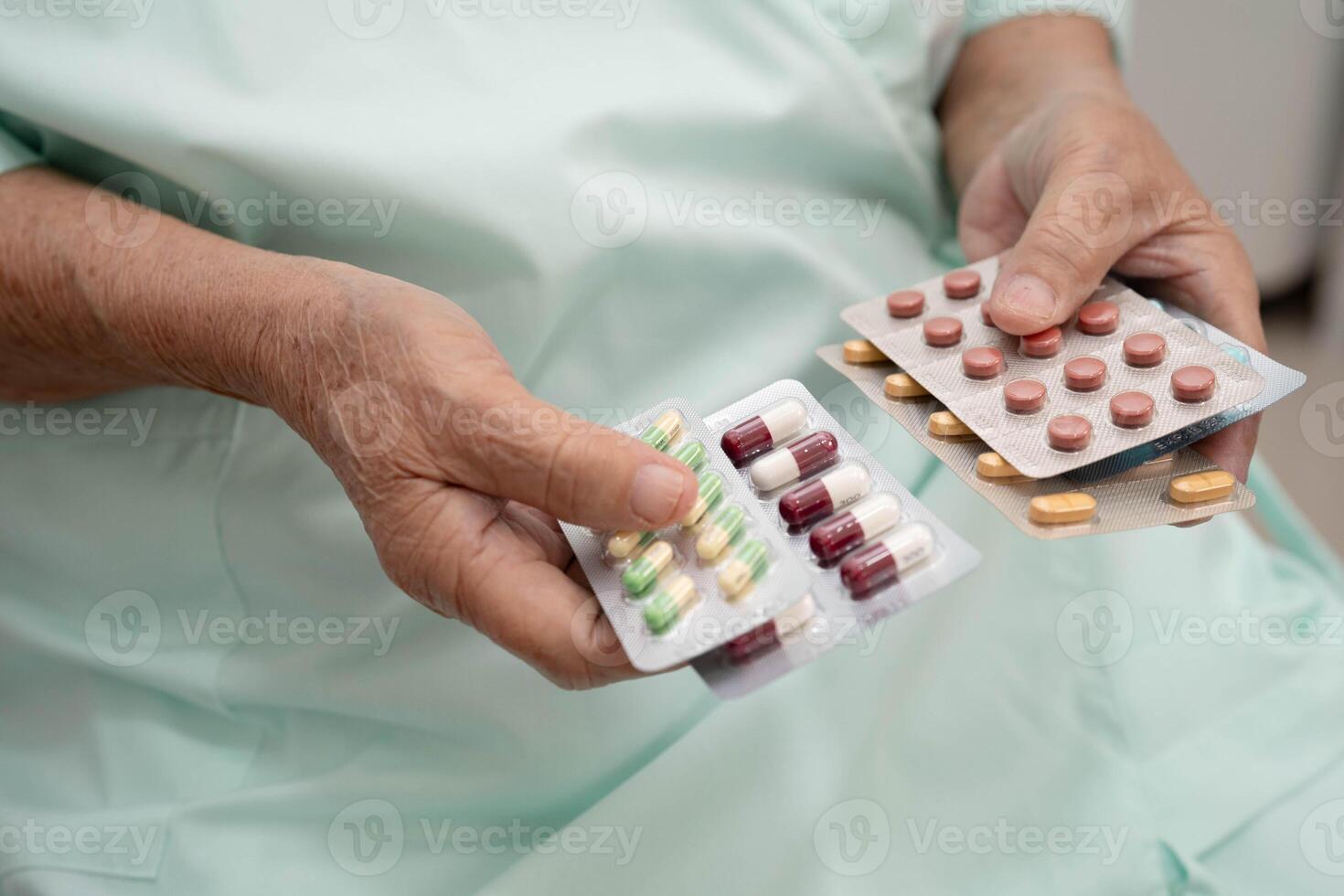 Asian elderly woman holding pill drug in hand, strong healthy medical concept. photo