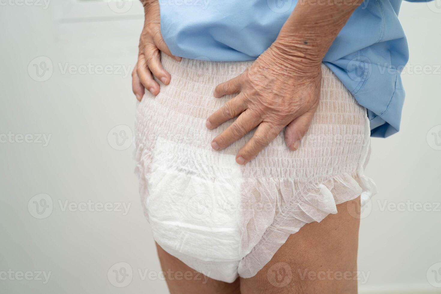 Asian senior woman patient wearing adult incontinence diaper pad in hospital. photo