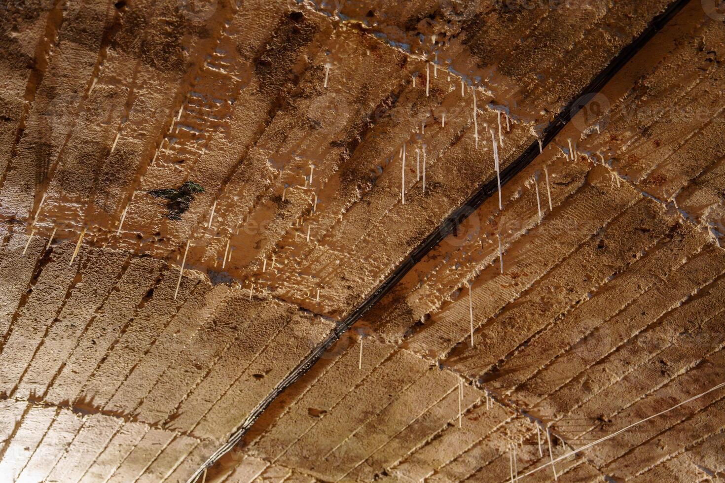 The stalactites are formed from dissolved minerals in water that drips from the roof of the mine shaft. Over time, the minerals build up and form the stalactites. photo