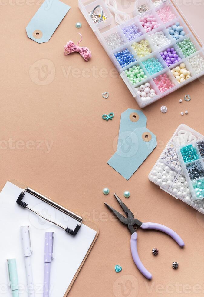 Crafting supplies arranged on a workspace with beads, tools, tags for personalized jewelry making photo
