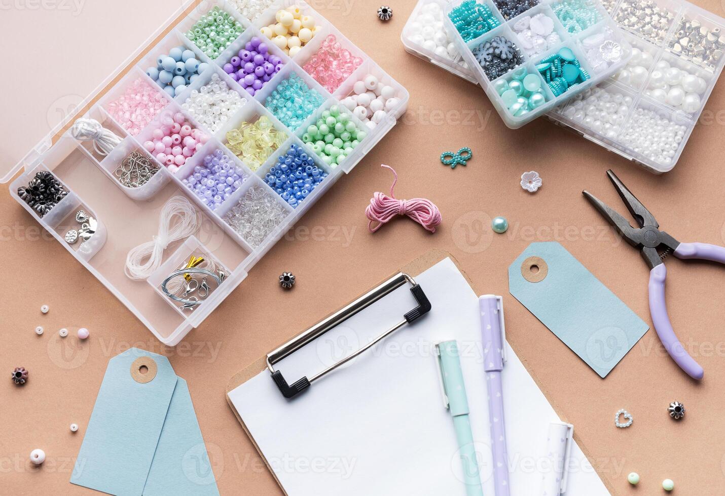 Crafting supplies arranged on a workspace with beads, tools, tags for personalized jewelry making photo