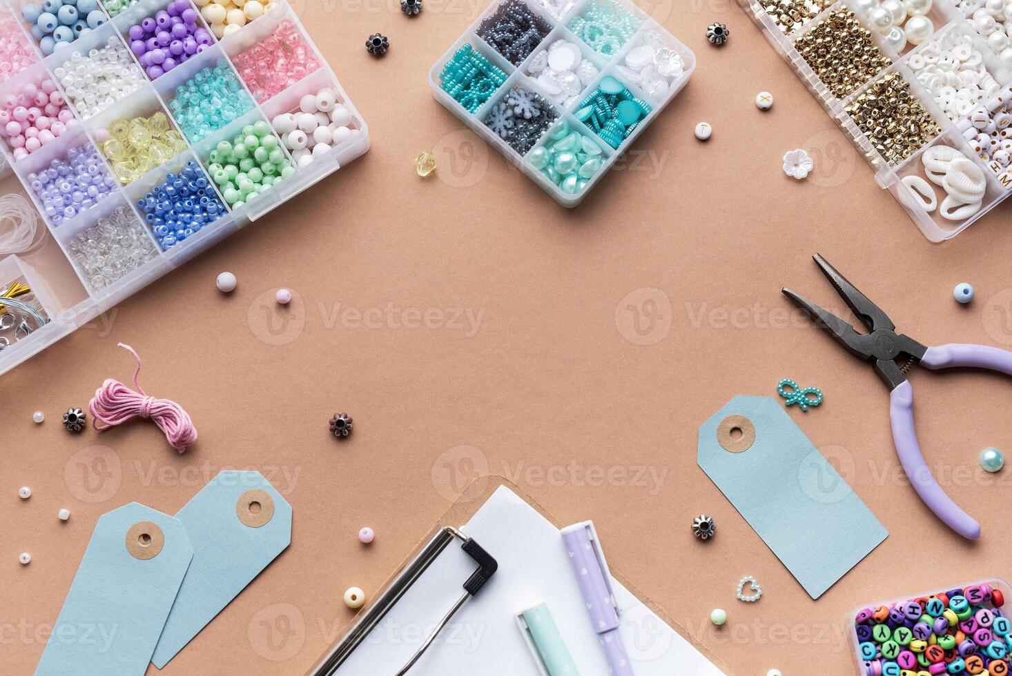 Crafting supplies arranged on a workspace with beads, tools, tags for personalized jewelry making photo