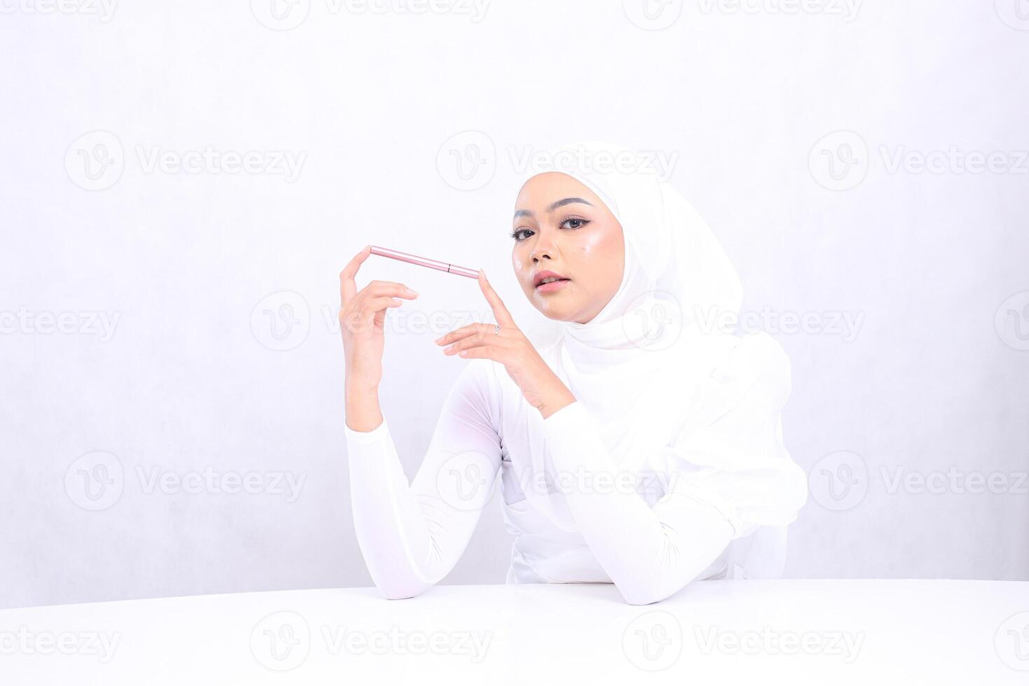 closeup Young woman indonesia veil relax look at camera both hands hold eyebrow pencil with clean healthy shiny skin isolated on white background. cosmetic advertising, eyebrow dye, eyebrow mock up photo