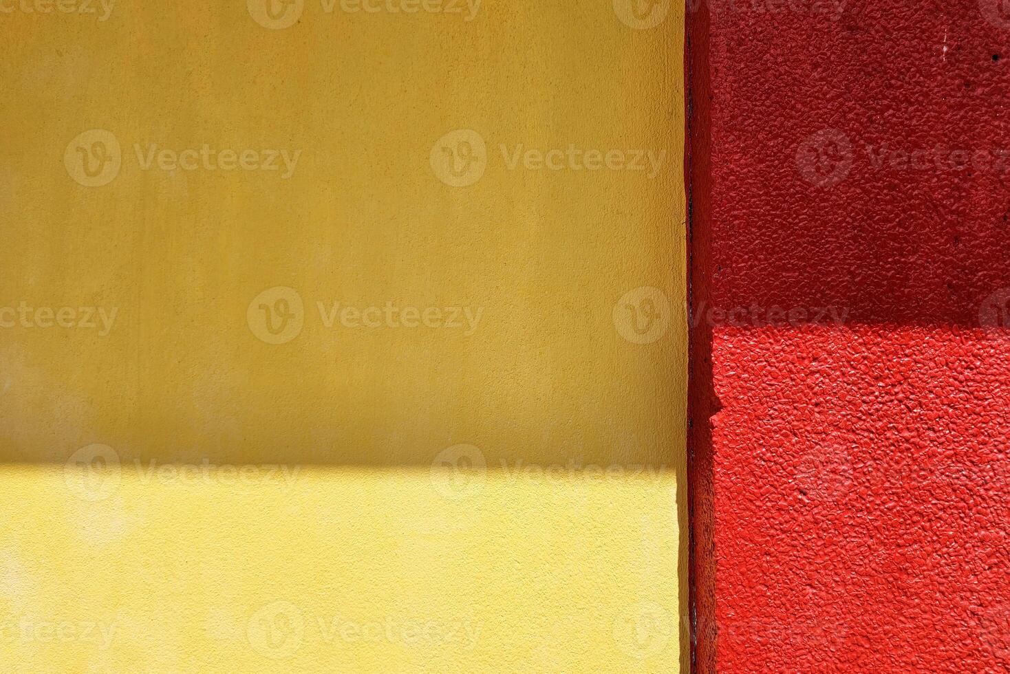 Yellow Concrete Wall and Red Pole with Light Beam and Shadow. photo