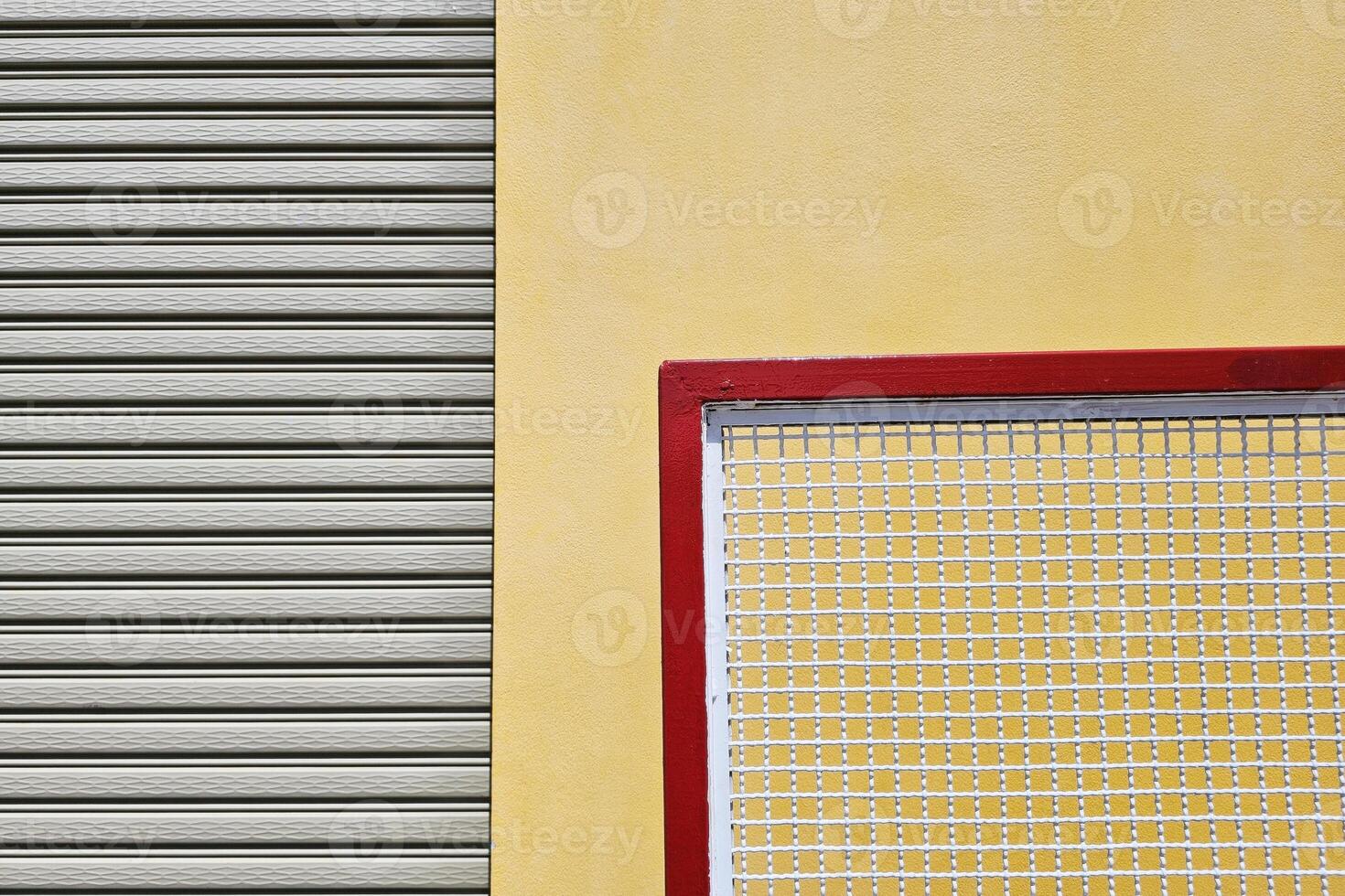 Close up Movable Metal Fence with Foldable Door and Yellow Concrete Wall Background. photo