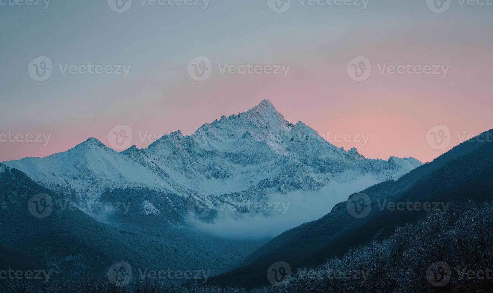 A mountain range with a mountain in the background and a pink sky photo