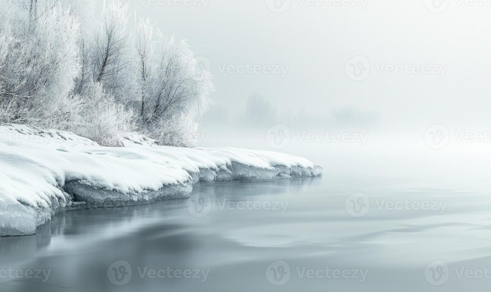 A snowy landscape with a body of water and trees in the background photo