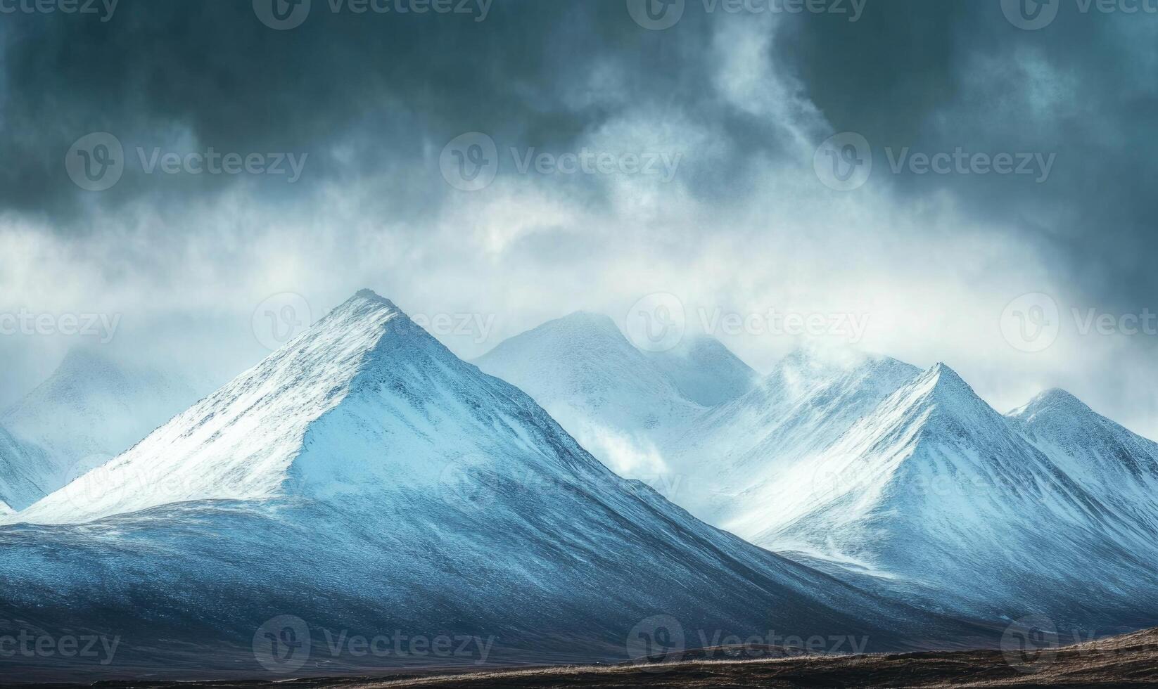 The mountains are covered in snow and the sky is cloudy photo