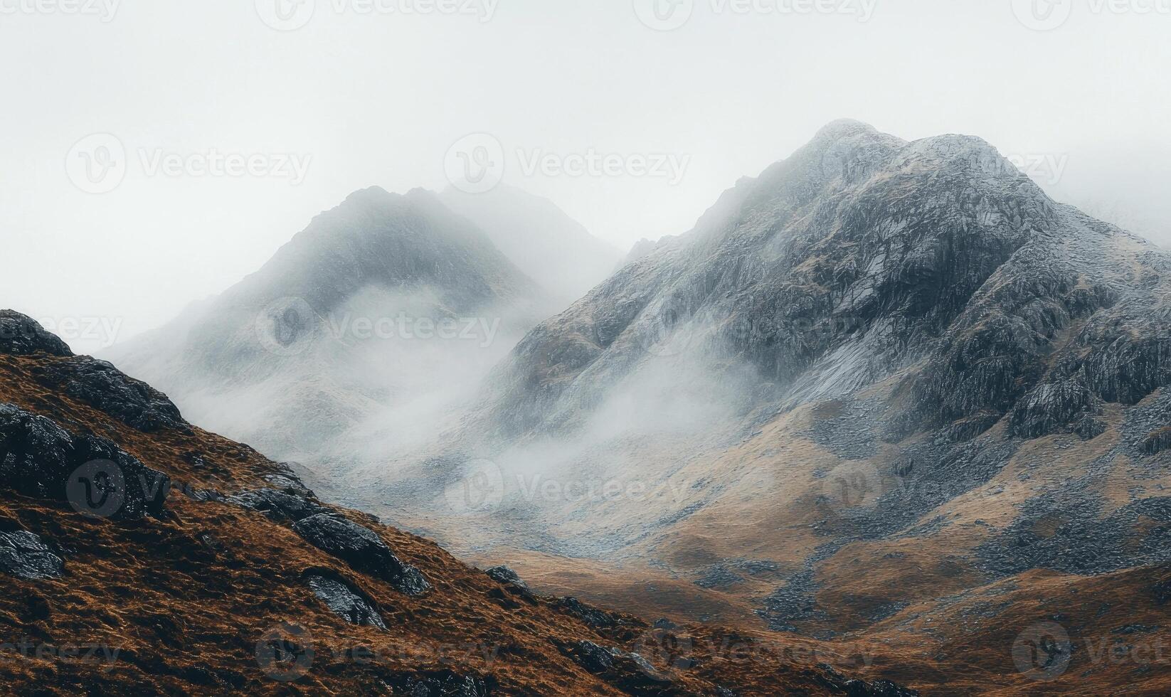 The mountains are covered in snow and the sky is cloudy photo