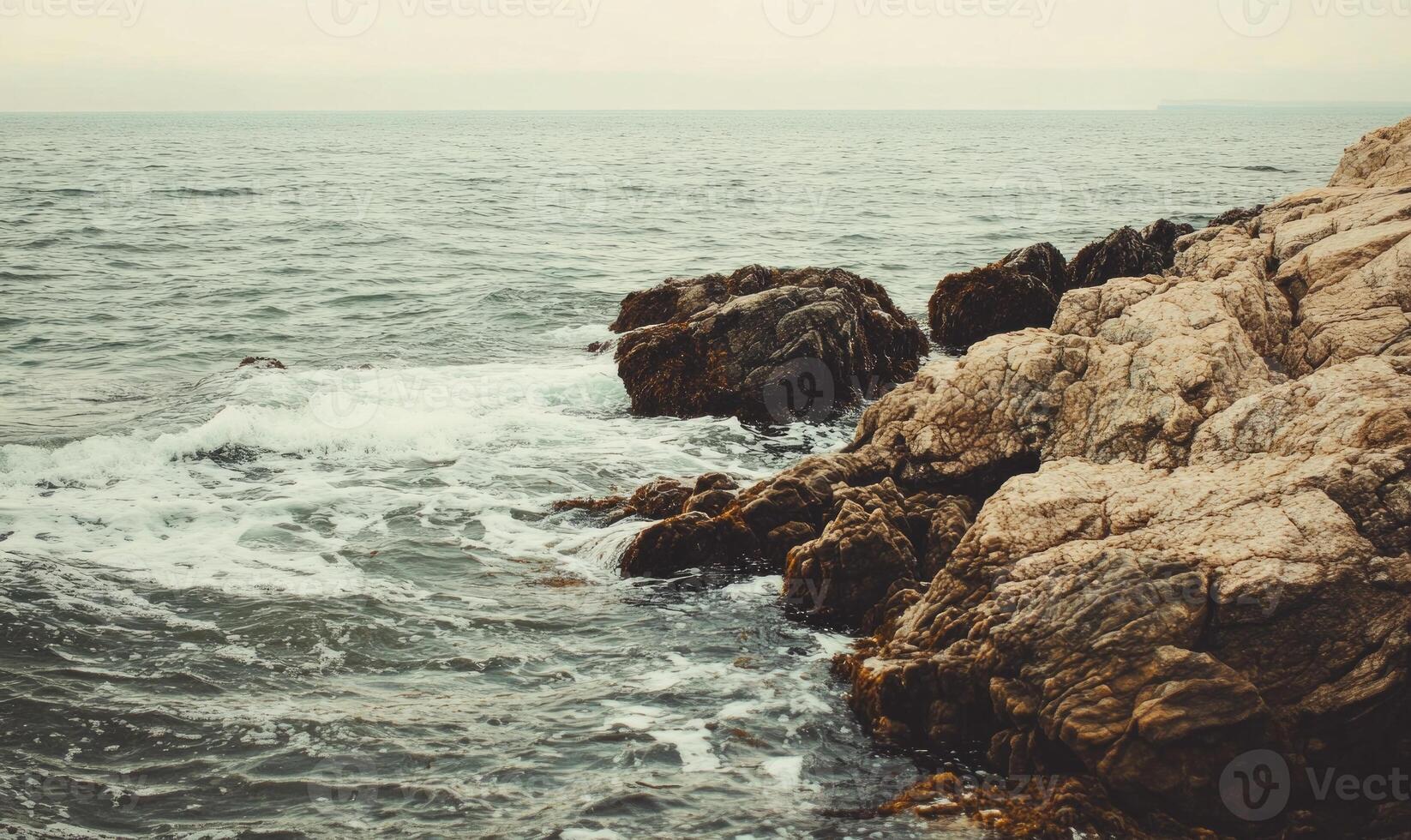 The ocean is calm and the rocks are large photo