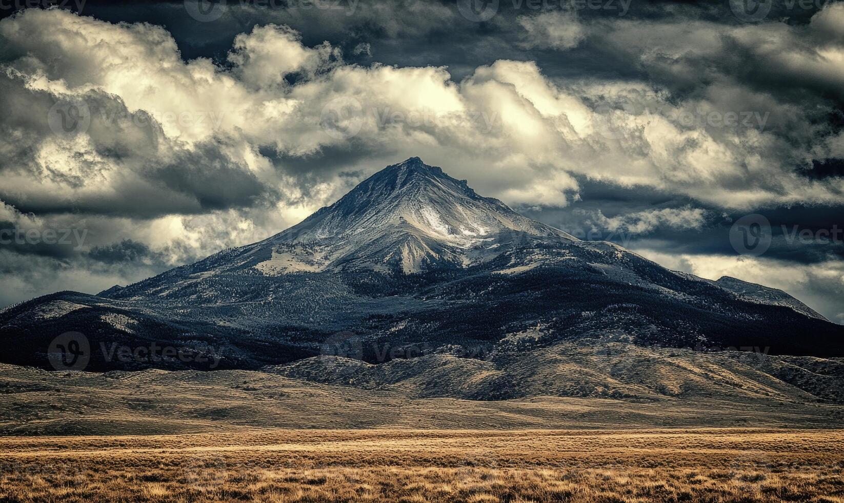 A mountain with a cloudy sky in the background photo