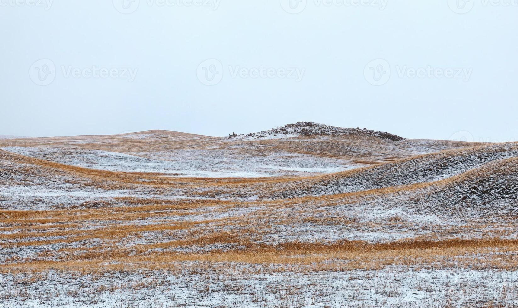 A snowy field with a hill in the background photo