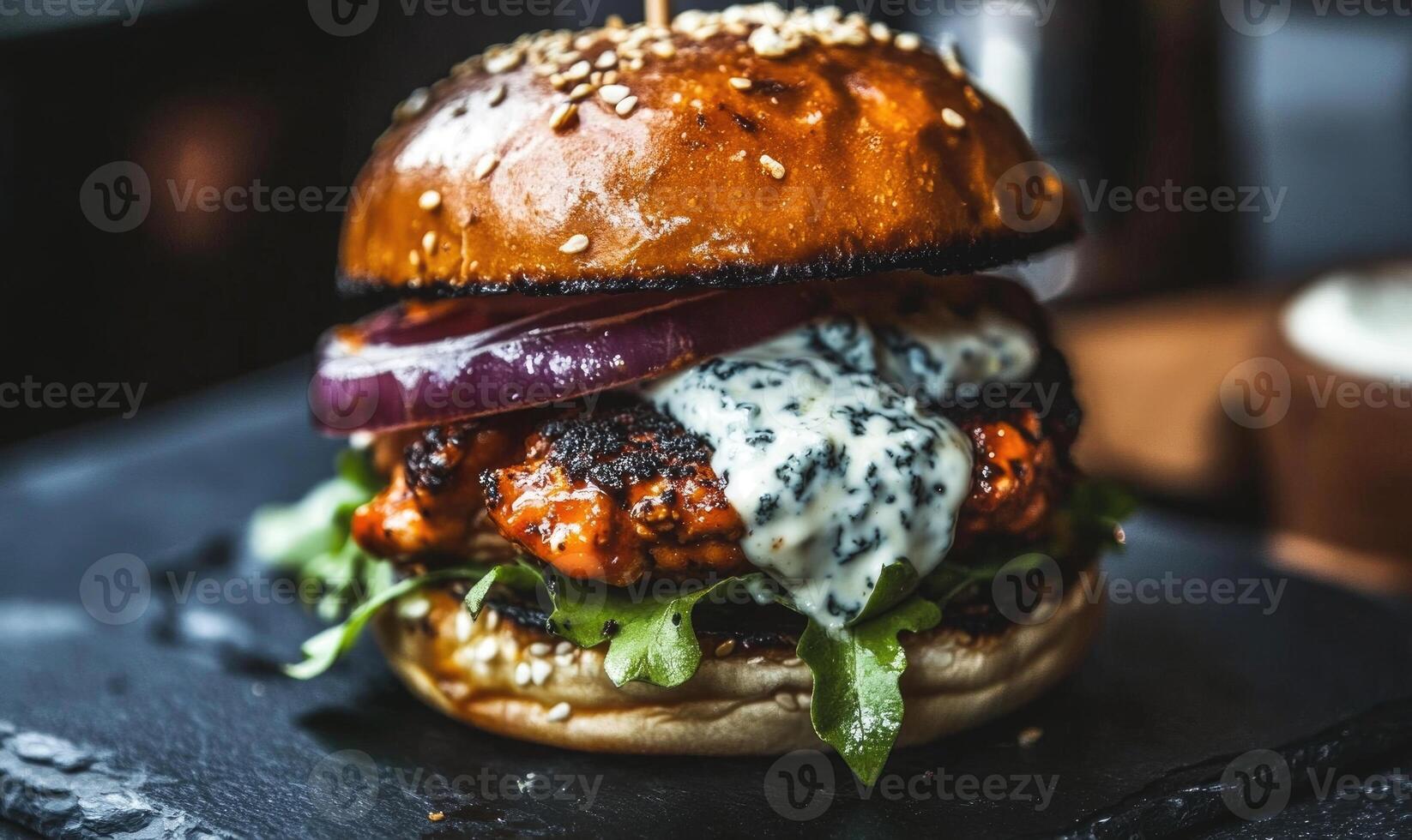 A burger with a slice of onion and a dollop of blue cheese photo