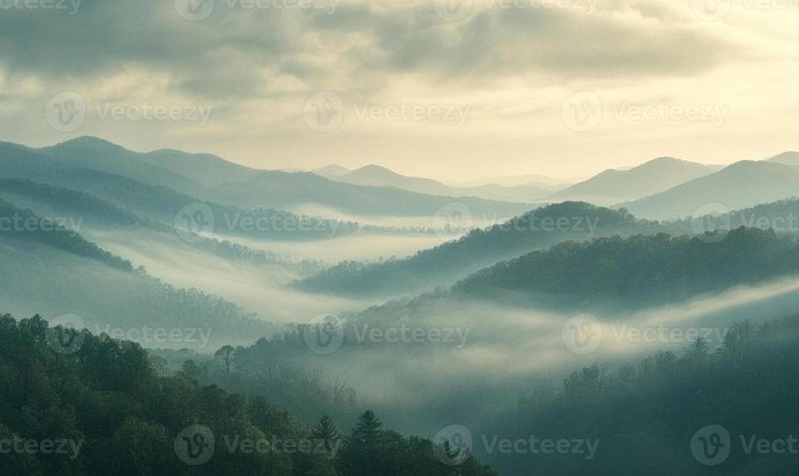 The mountains are covered in fog and the sky is cloudy photo