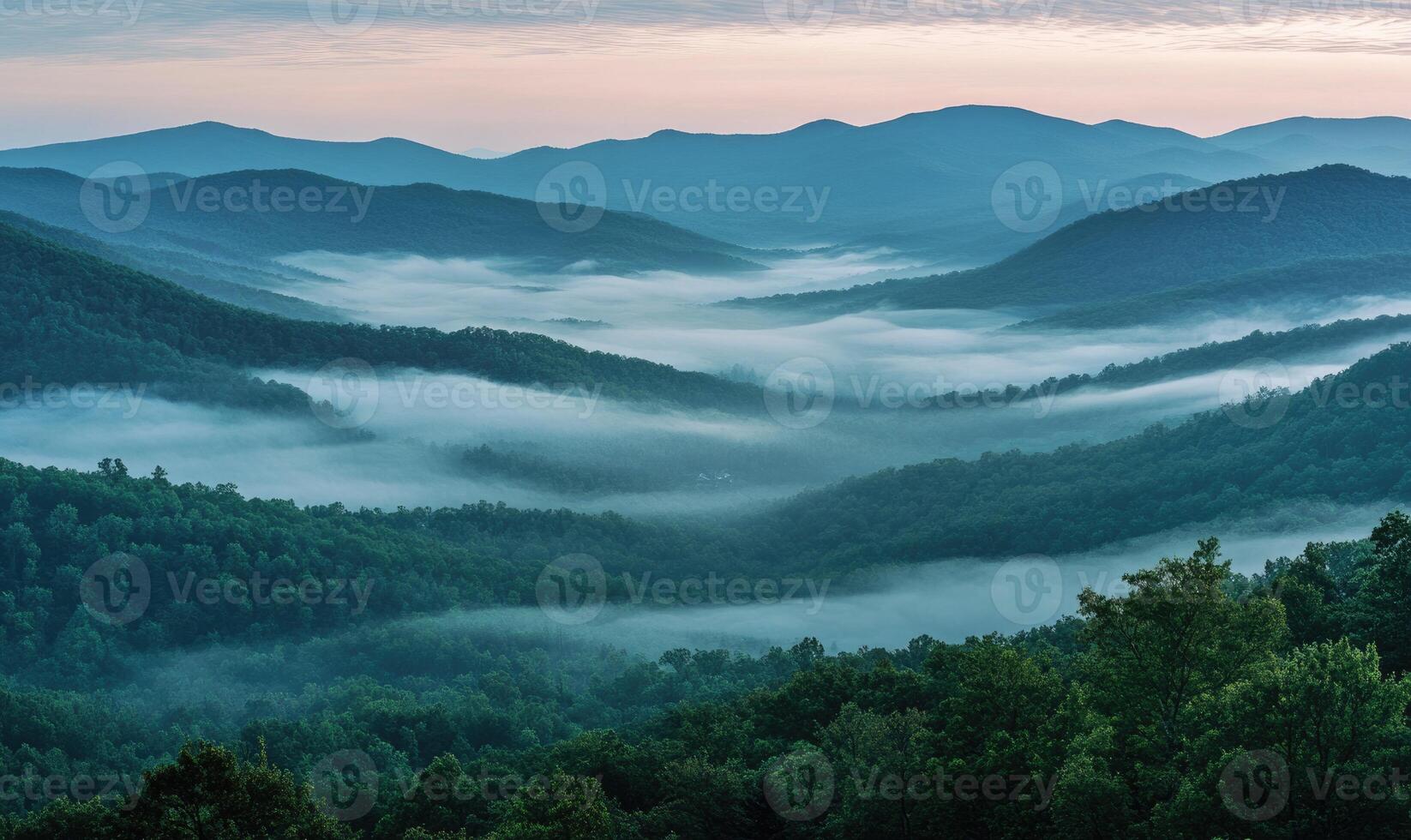 The mountains are covered in fog and the sky is a beautiful shade of blue photo