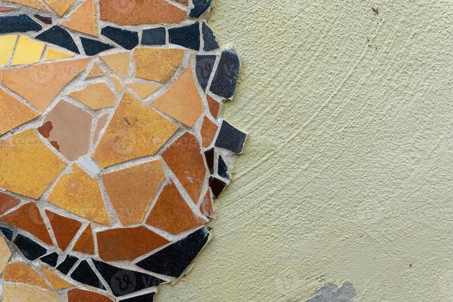 A close-up of a colorful mosaic on a light green wall, showcasing the intricate patterns and textures photo