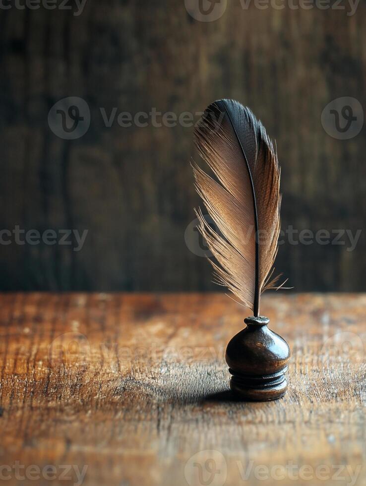 A feather quill on top of a wooden table photo